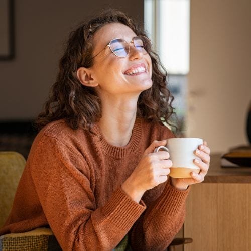 Happy Woman Enjoying Coffee at Home